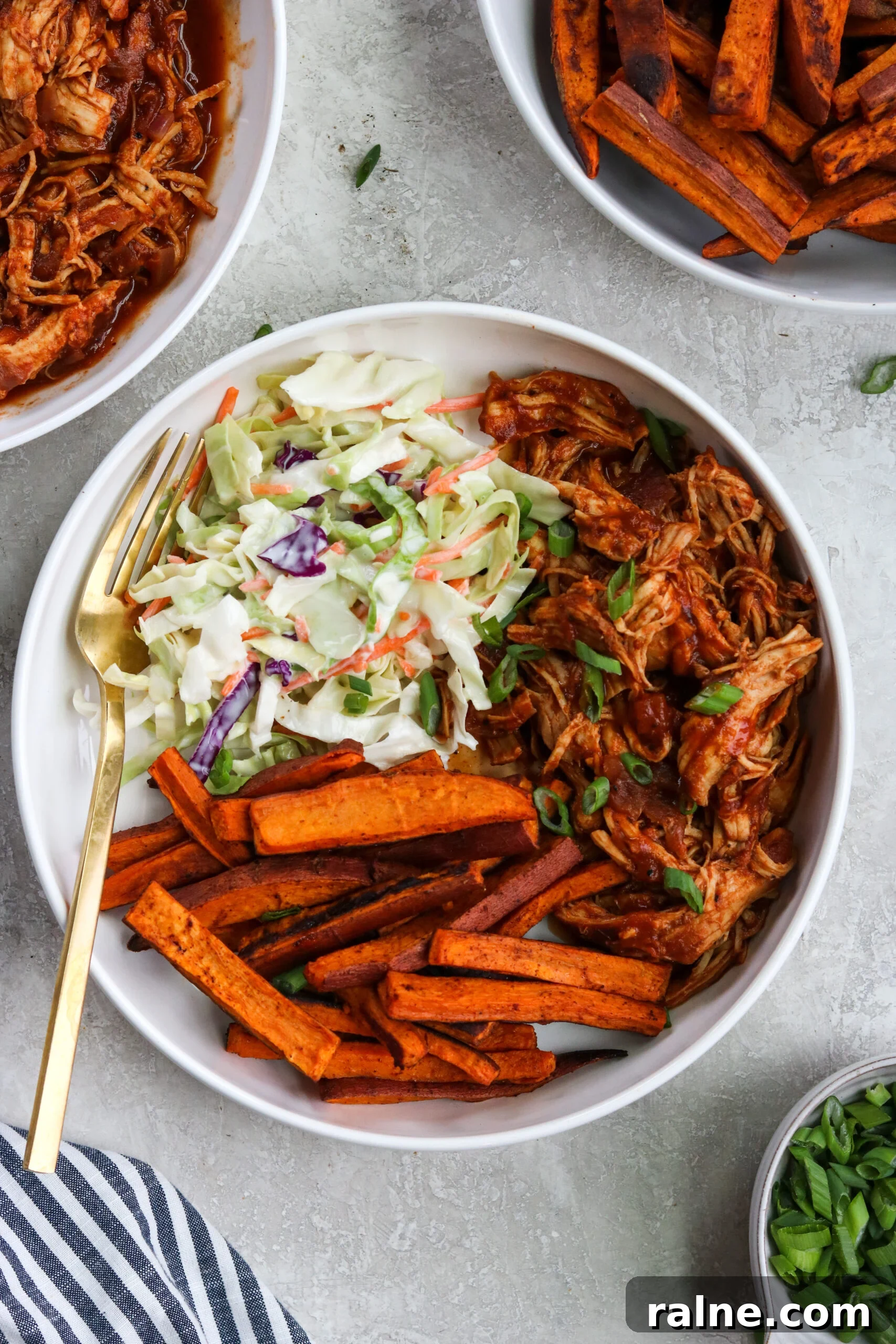 Instant Pot BBQ Chicken Bowls with Tangy Coleslaw Recipe 2 Instant Pot BBQ Chicken bowls with healthy cabbage recipe and homemade sweet potato fries in a white bowl with a gold fork