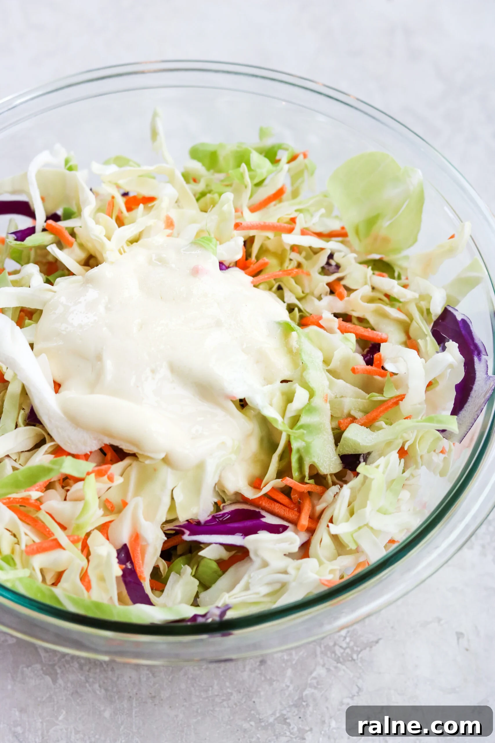 Instant Pot BBQ Chicken Bowls with Tangy Coleslaw Recipe 5 shredded cabbage, carrots, and mayo in a clear glass bowl