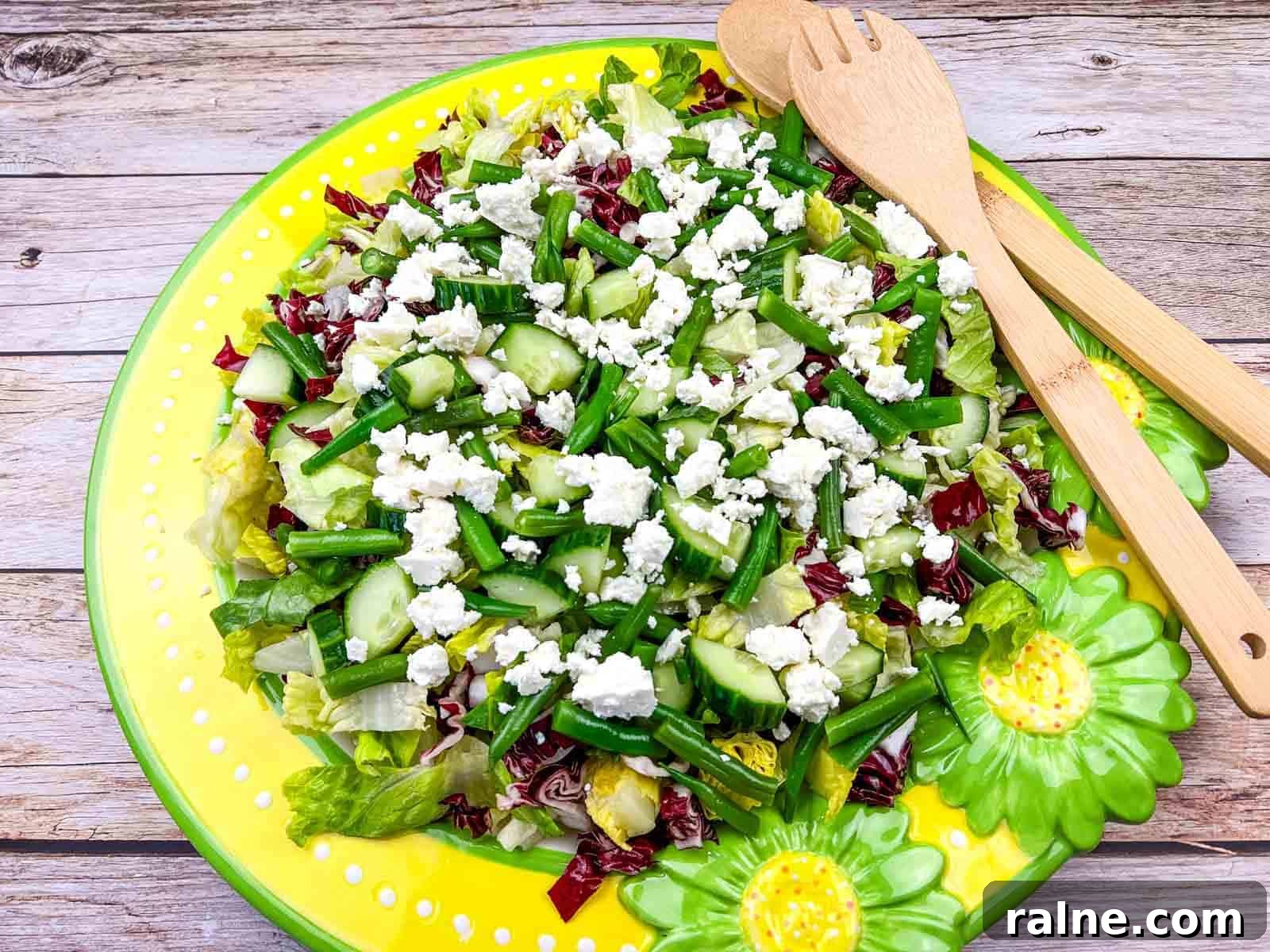 23 Make-Ahead Salads That Stay Fresh in the Fridge and Lunch Bag 13 Mediterranean Chopped Salad with crumbled feta cheese, on a yellow plate with flower designs.