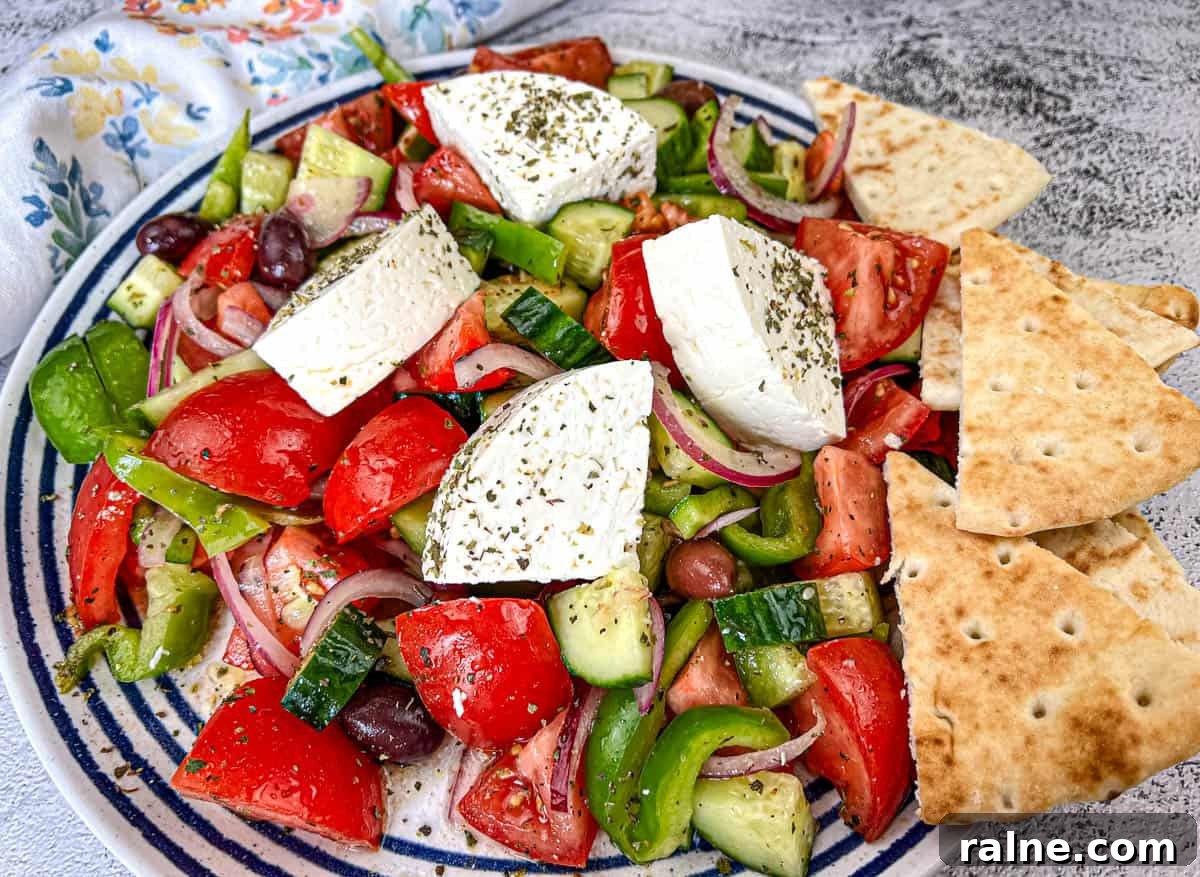 23 Make-Ahead Salads That Stay Fresh in the Fridge and Lunch Bag 16 Horiatiki Salad with feta cheese on top served on a plate.