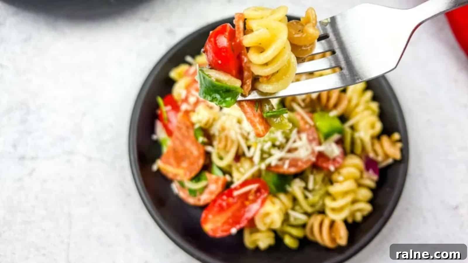23 Make-Ahead Salads That Stay Fresh in the Fridge and Lunch Bag 9 A fork with pizza pasta salad in a bowl.