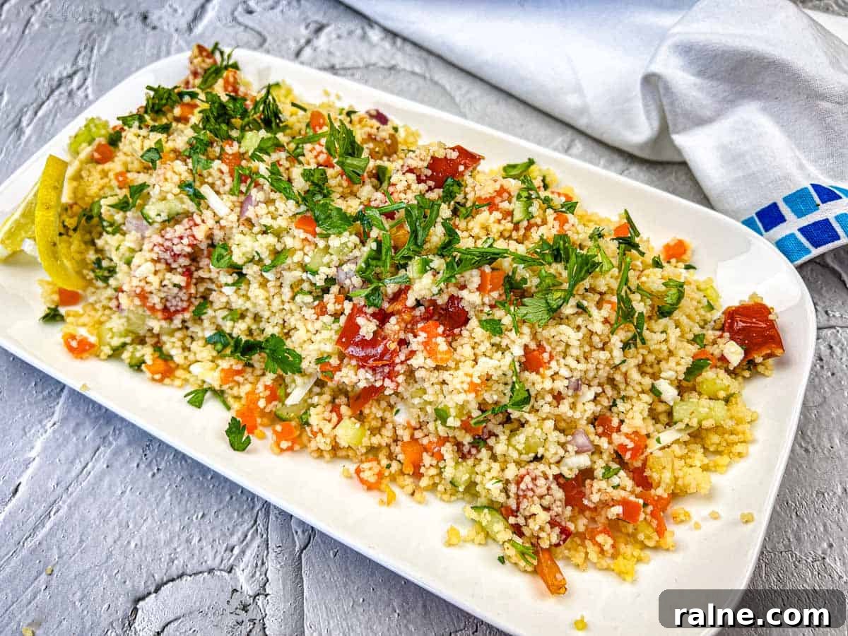 23 Make-Ahead Salads That Stay Fresh in the Fridge and Lunch Bag 10 A plate of Mediterranean Couscous Salad With Smoked Tomatoes topped with parsley.