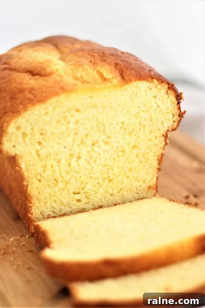 gluten free brioche loaf with a few slices cut on a wooden cutting board