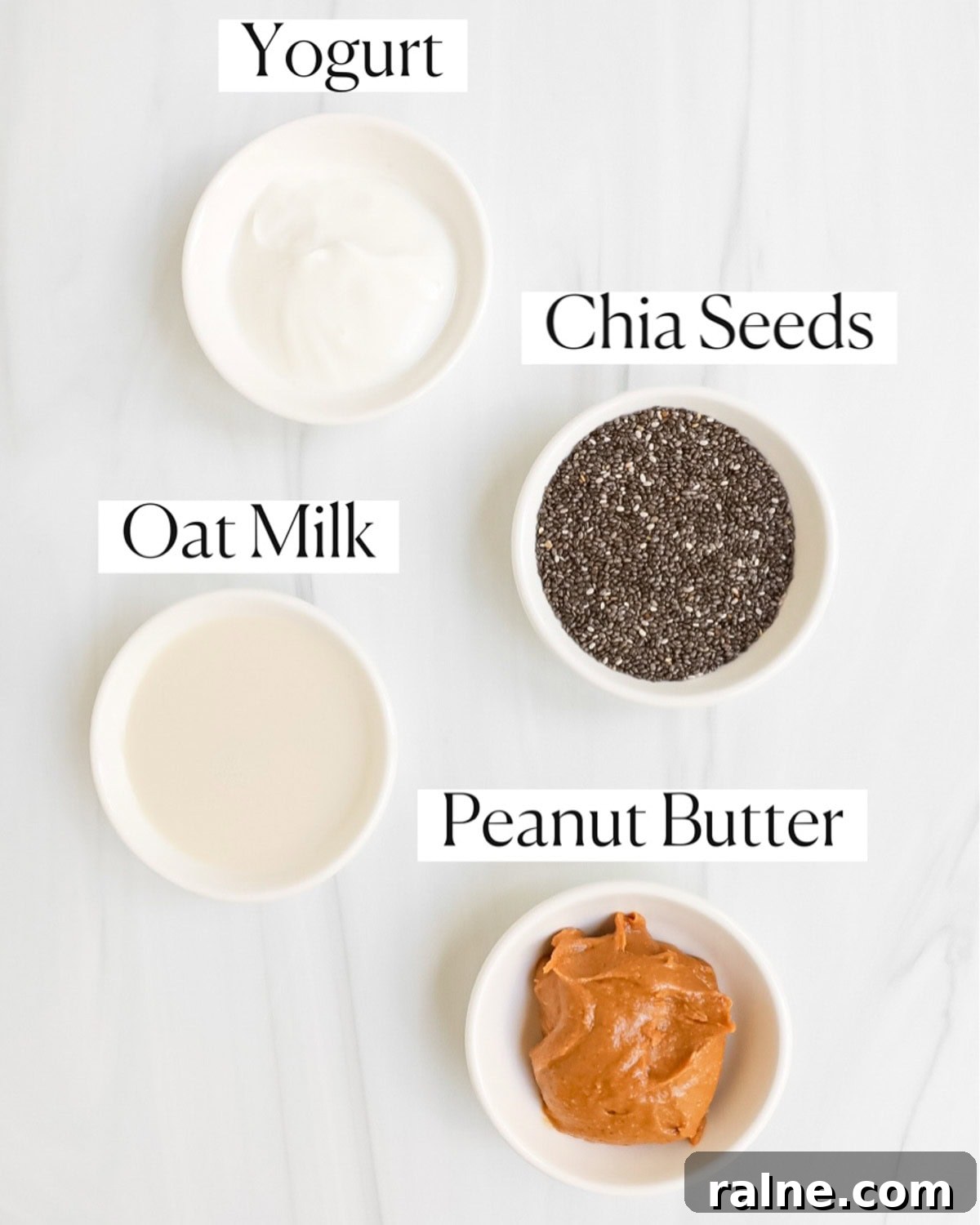 Labeled ingredients in small white bowls including: yogurt, chia seeds, oat milk, peanut butter.