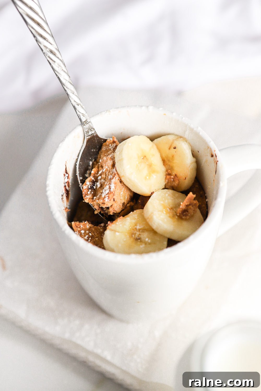 Gluten-Free Banana Bread Mug Cake Recipe (Quick Single-Serve) 3 a spoon being inserted in a healthy banana bread mug cake