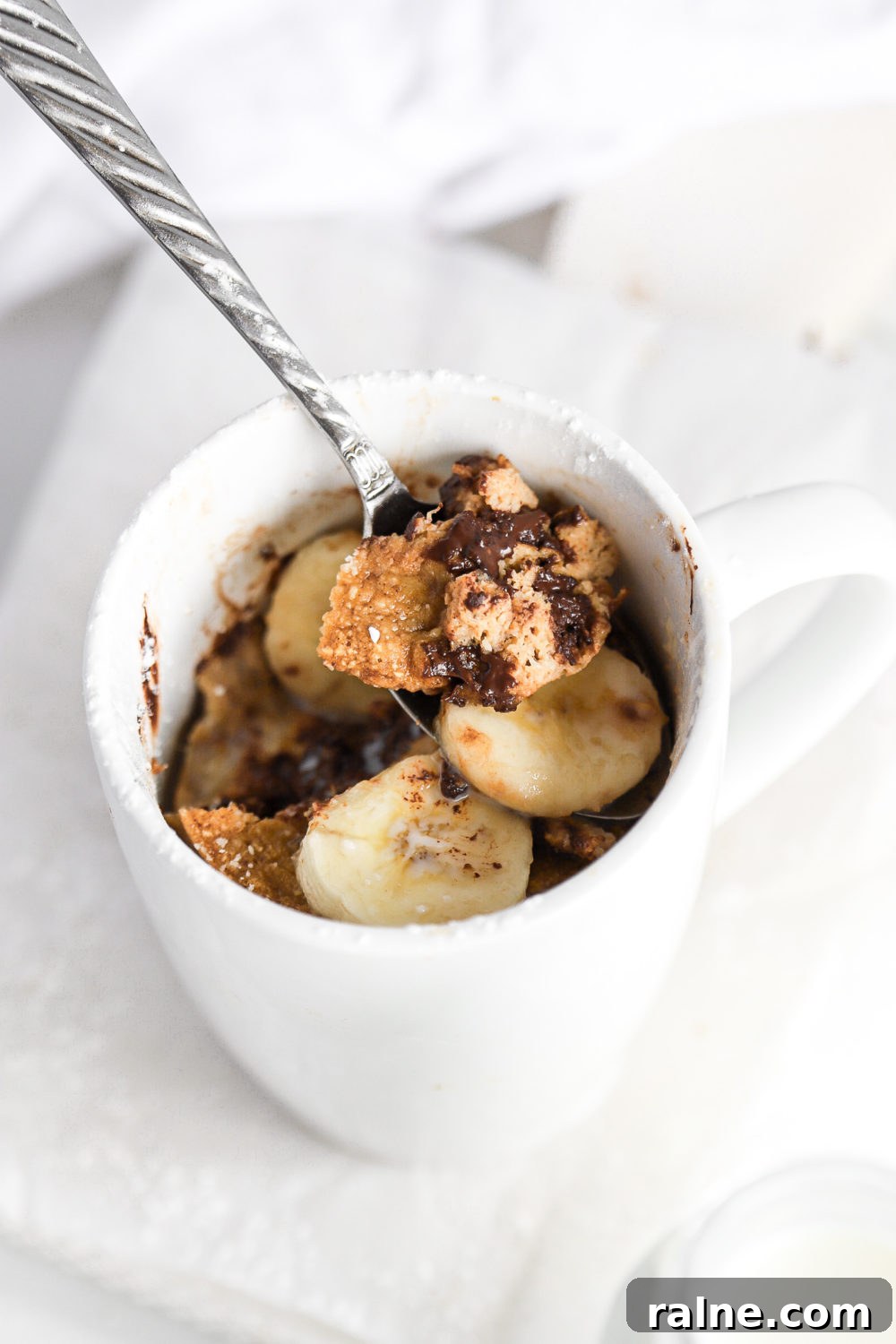 Gluten-Free Banana Bread Mug Cake Recipe (Quick Single-Serve) 5 a spoon being dipped into a healthy high protein banana mug cake