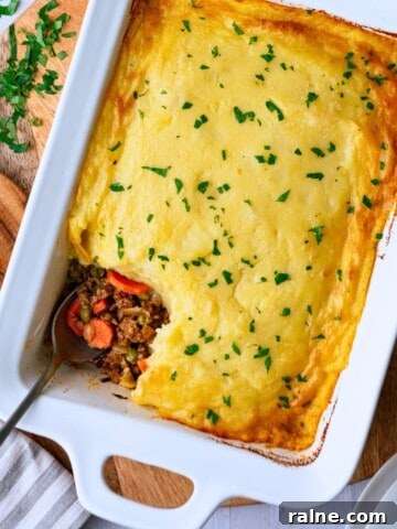 A shepherd's pie in a rectangular casserole dish with a scoop taken out of a corner.