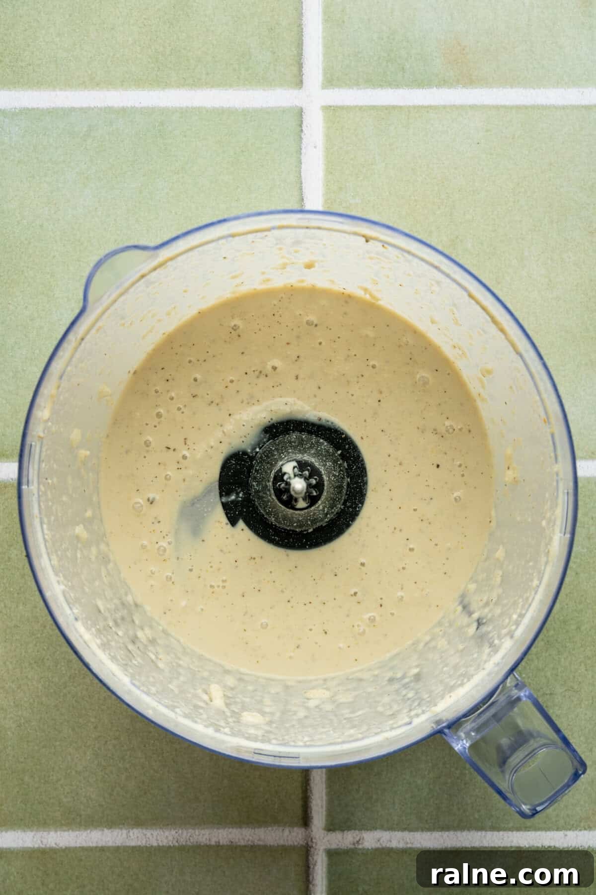 A blender filled with a creamy white sauce.