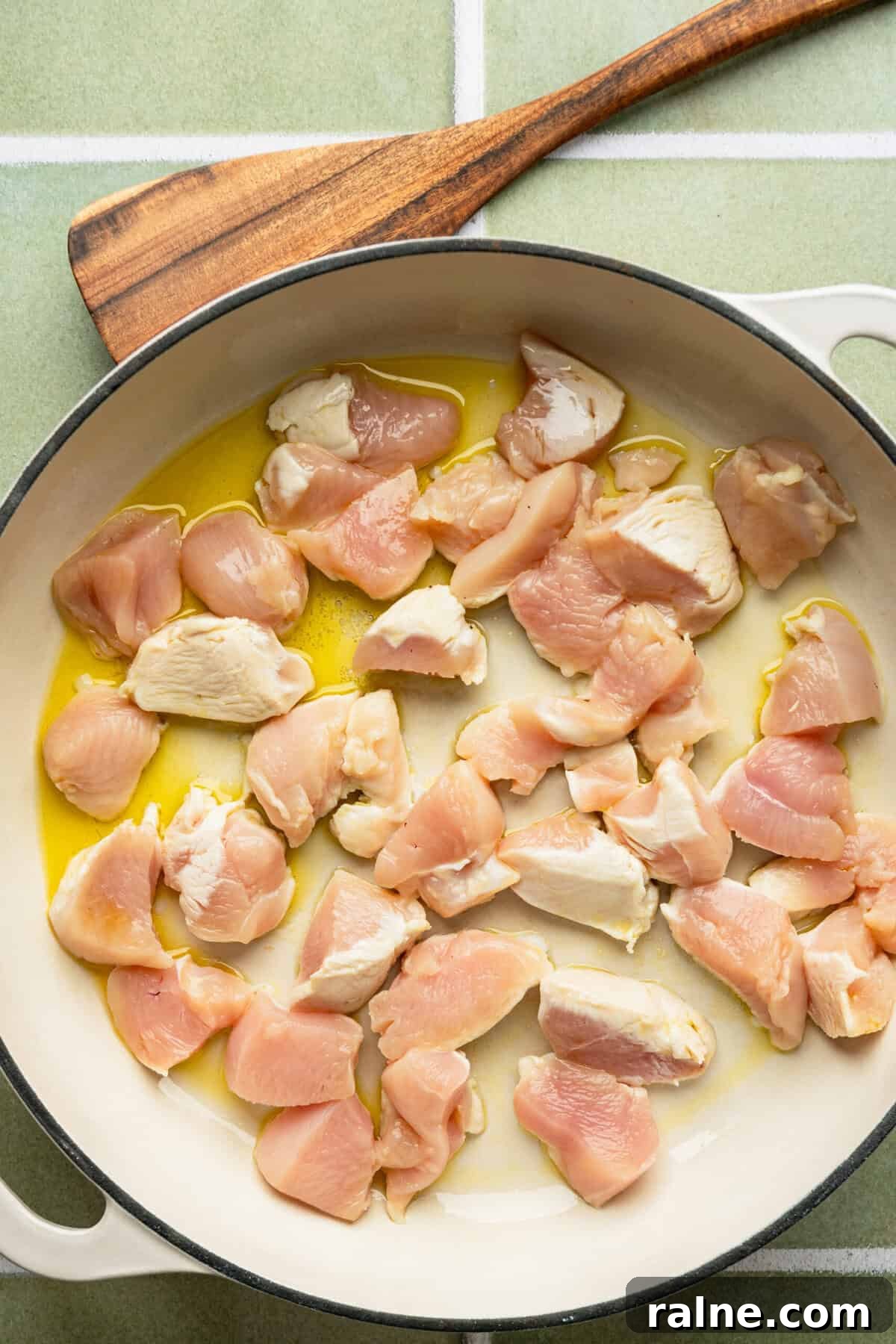A pan filled with uncooked chicken pieces. 