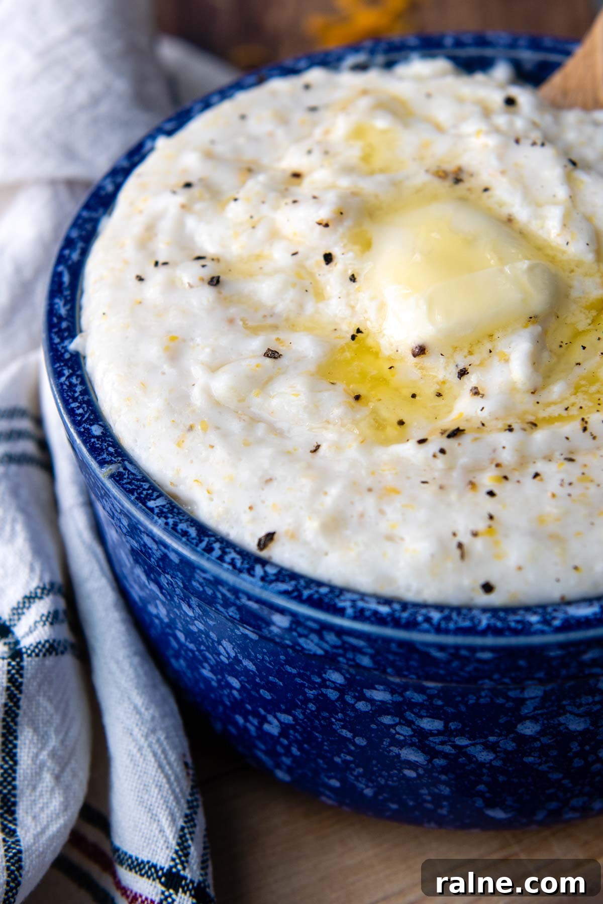 a bowl of grits with melted butter and cracked pepper on top.