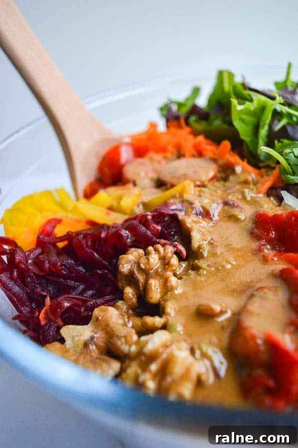 A close-up of a mixed salad with a creamy brown dressing