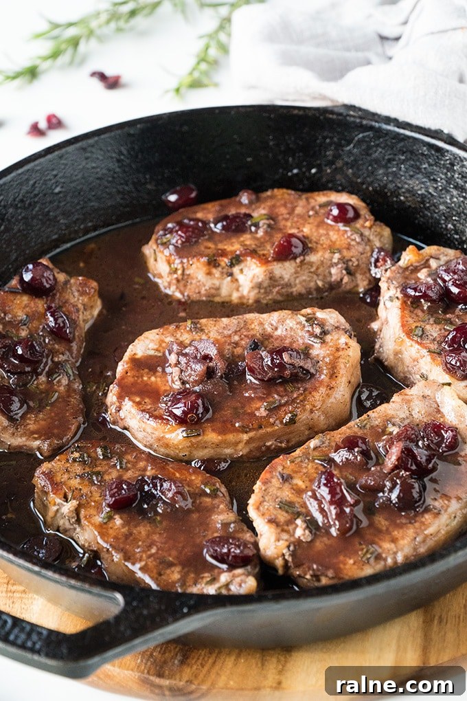 Pork chops with port wine and cranberries in a skillet.